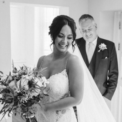 Bride in bridal suite of Rowton Castle Shropshire, showing wedding dress off to father Black and white photo of bride and groom during first dance at Hadley Park House photographed by Shropshire Wedding Photographer R&R Photography