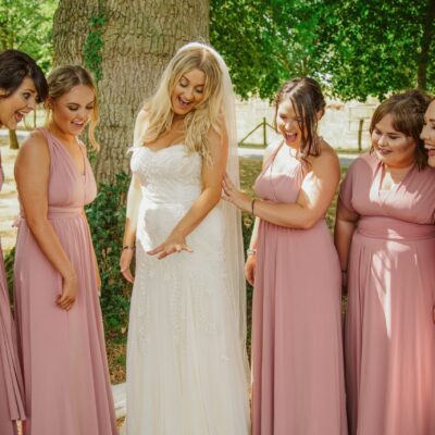 Bride showing ring off to group of bridesmaids outdoors Black and white photo of bride and groom during first dance at Hadley Park House photographed by Shropshire Wedding Photographer R&R Photography