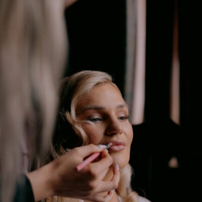 Close up photo of bride having lipstick applied during bridal preparations photographed by Shropshire based Wedding Photographer R&R Photography
